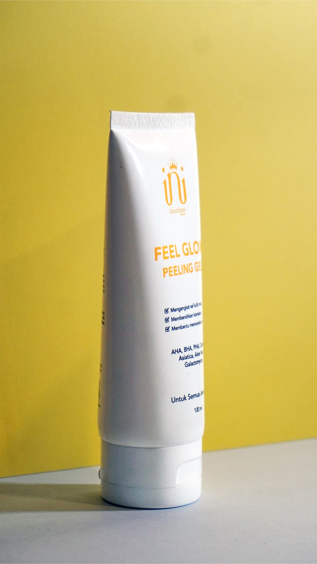 FEEL GLOW PEELING GEL dari sisi samping pada latar kuning